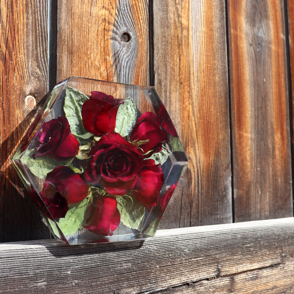Hexagonal resin block with red roses against a wooden background