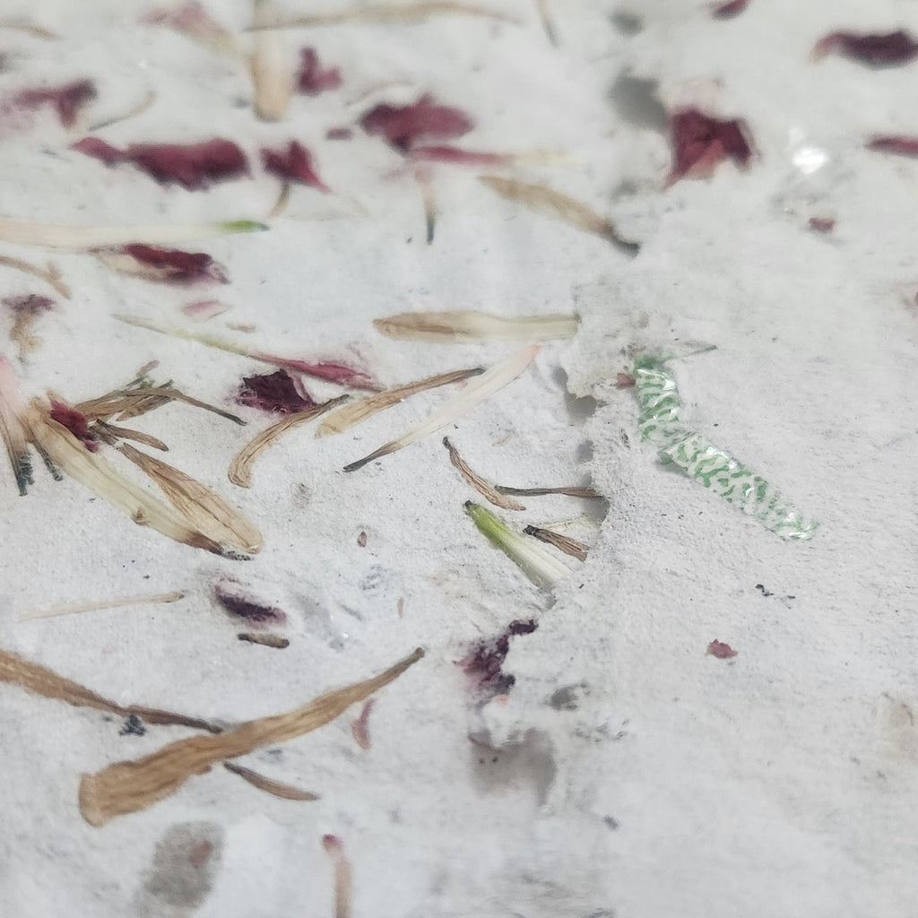 Close up of handmade recycled paper with dried flower petals and natural edges
