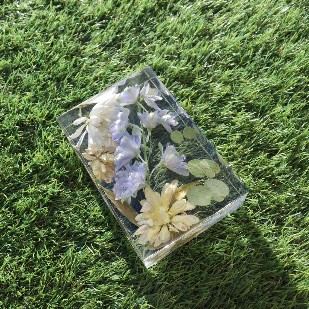 Close-up of dried florals suspended in a clear resin block