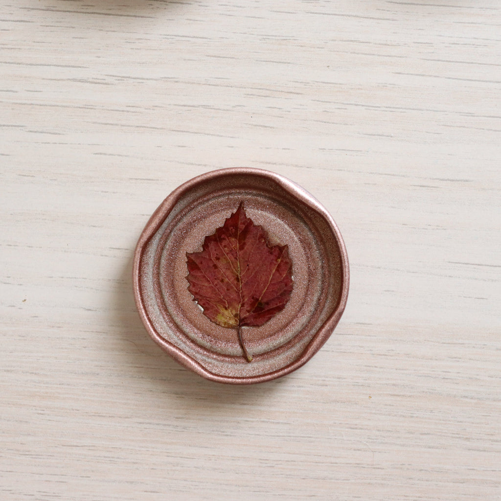 red leaf sealed by resin in a rose gold jar lid